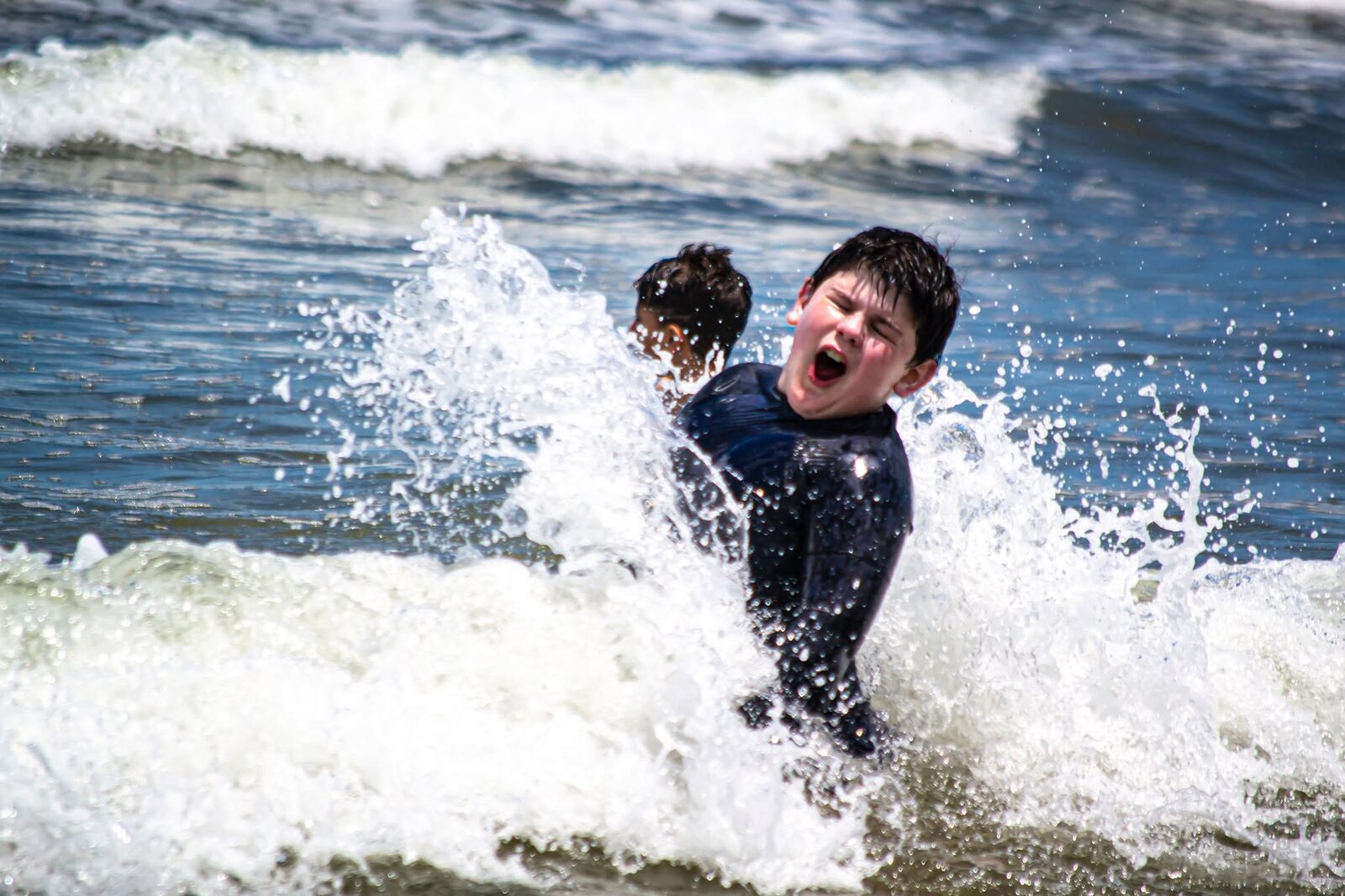 Menino encarando a onda no mar